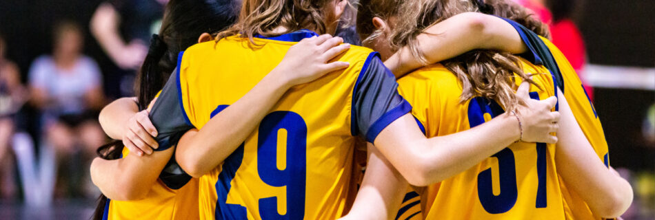 a team of girls huddled together on a court