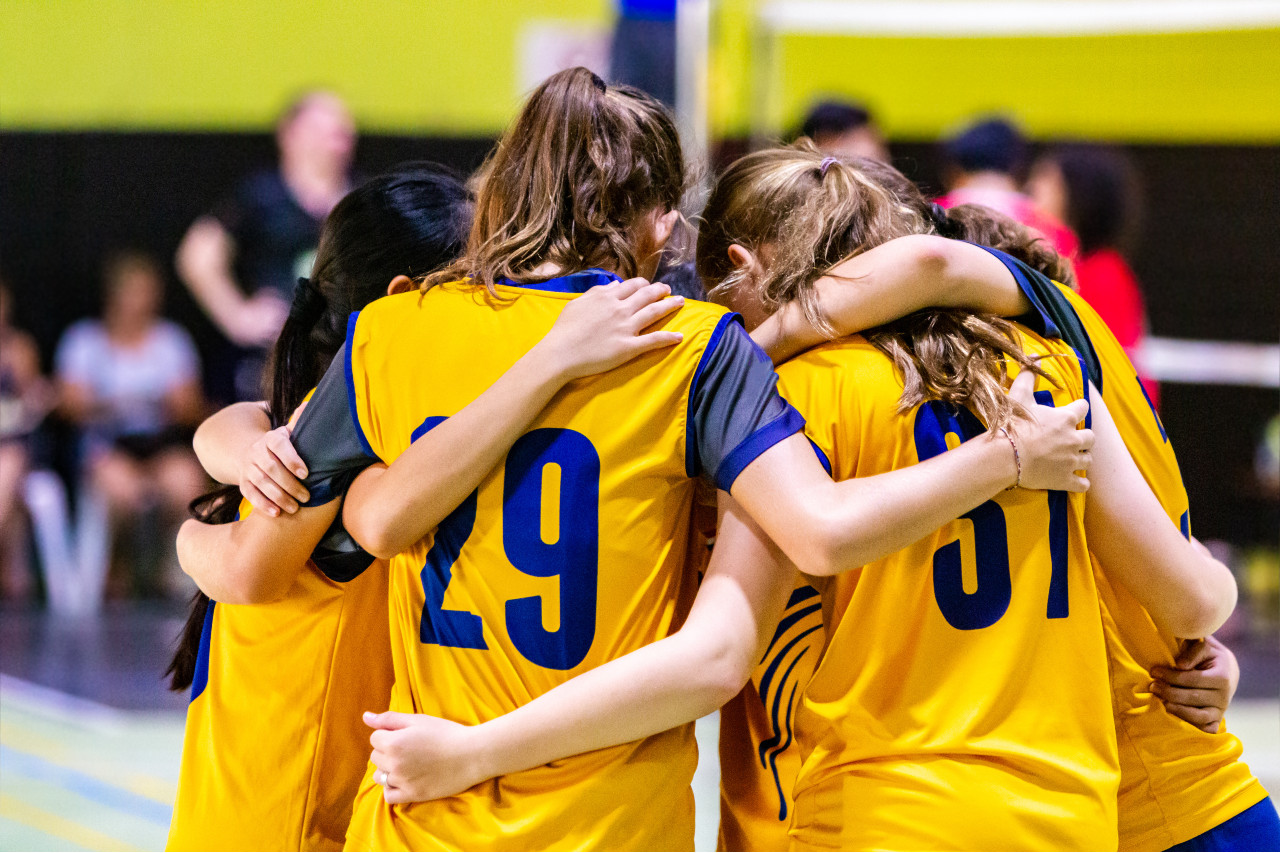 a team of girls huddled together on a court