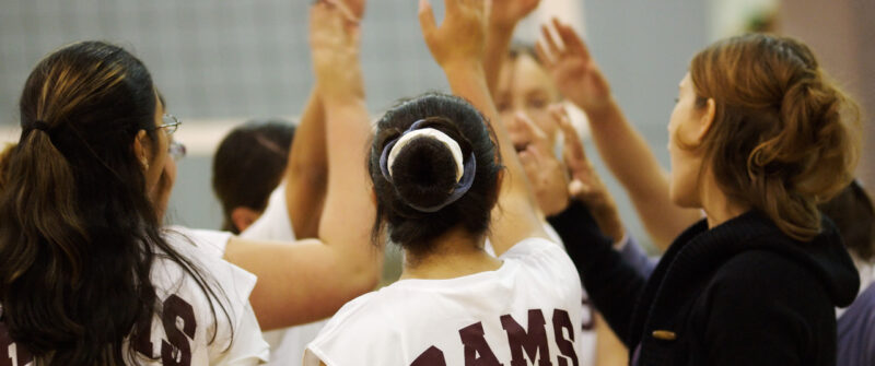 a girl's volleyball team huddle