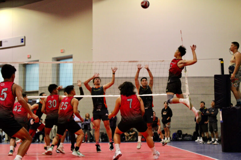 lefty attacking jumping in the air attacking a volleyball