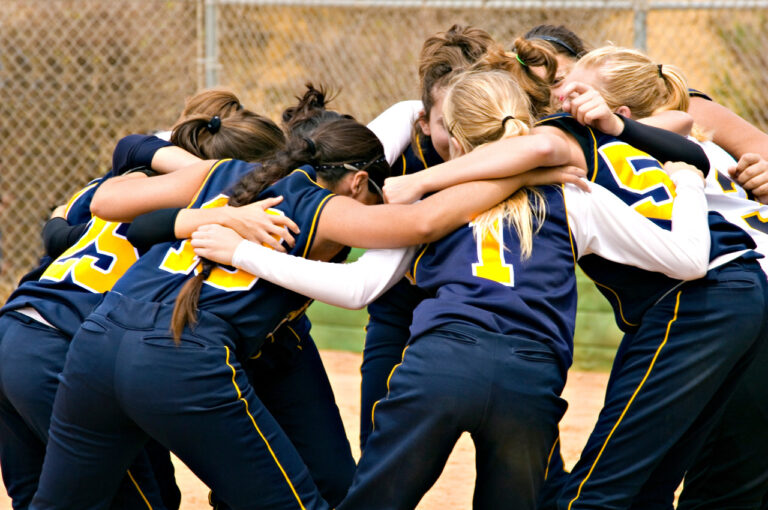 a team of young softball players in a huddle